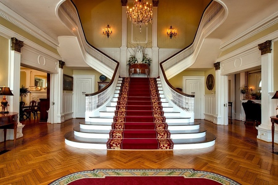 large foyer stairs facing front door mansion red carpet min - Feng Shui of Stairs Facing Front Door (Inside & Outside)